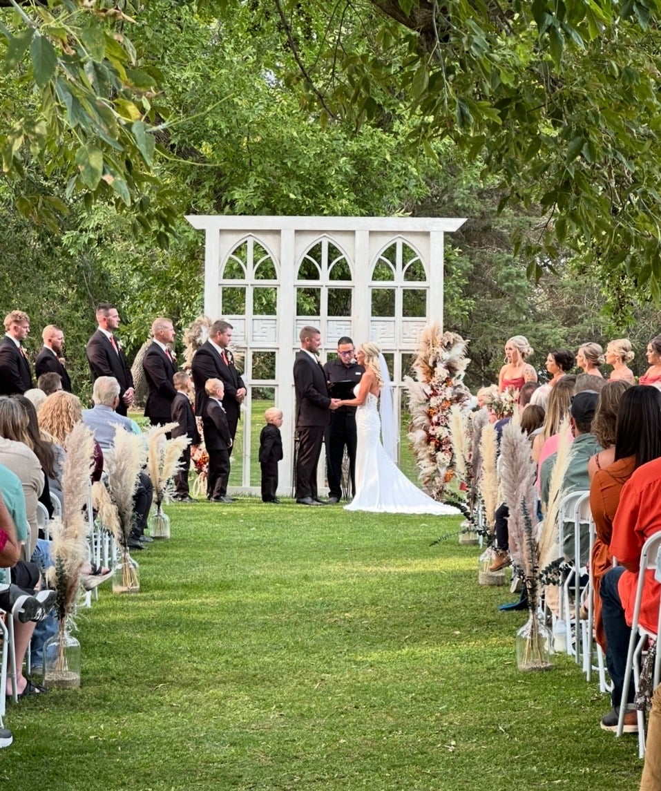 Outdoor ceremony with white arbor